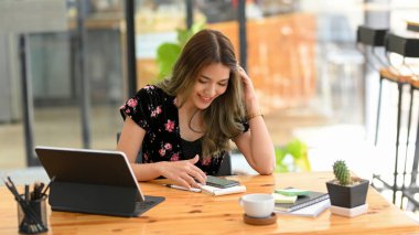 Çekici Asyalı kız üniversite öğrencisi çevrimiçi derse ara veriyor, akıllı telefon kullanıyor, online başvuru videolarını izliyor..