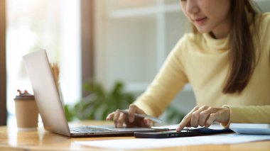 Keskin nişancı, Asyalı genç bir üniversite öğrencisi dizüstü bilgisayarla çalışıyor ve birlikte çalıştığı yerde akıllı telefonunu kullanıyor..