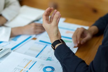 Kesilmiş ve yakın plan görüntüler, iş insanları çalışma alanlarında tartışıyor ve toplantıda emlak yatırımları planlıyorlar.