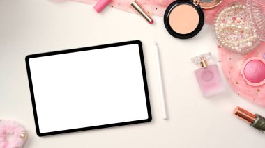 Kadın çalışma alanı, tablet beyaz ekran modeli, stilus kalem, makyaj malzemeleri ve beyaz masa arkasında pembe aksesuarlar olan kadınsı ofis masası. Genel giderler, düz yatarlar.