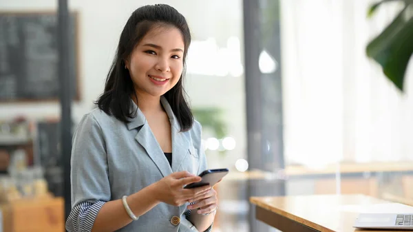 Una Mujer Traje Casual Gris Sienta Una Cafetería Usa Teléfono — Foto de Stock