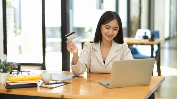 美丽的亚洲女商人在笔记本电脑上搜寻感兴趣的在线产品 并用信用卡支付 无灰社会 — 图库照片