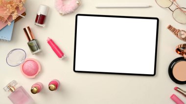 Beyaz arka planda dijital tablet beyaz ekran modeli ve kozmetik makyajlı güzellik blogcusu ya da makyöz çalışma alanı. Üst görünüm, düz uzanma