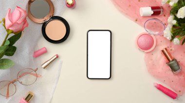 Beyaz arka planda, kadın pembe güzellik kozmetik ürünleri ve dekorlarıyla akıllı telefon boş ekranının bir kopyası. Üst görünüm, düz uzanma
