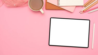 Dijital tablet touchpad beyaz ekran modeli, stilus kalem, çay fincanı, kırtasiye ve kopyalama alanı olan pembe bir çalışma alanı arkaplanı.