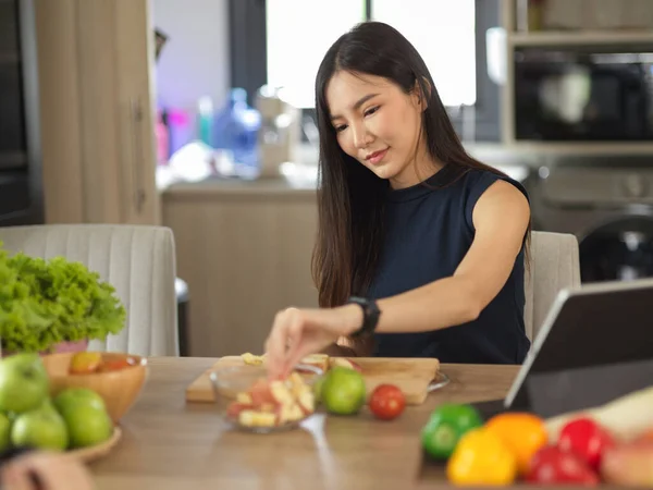 健康的なアジアの若い女性は 台所で彼女の健康的な飲み物やサラダのために果物や野菜を準備します 家庭料理のコンセプト — ストック写真