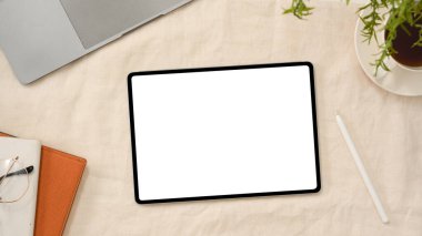 Stylus kalem, dizüstü bilgisayar, gözlük, not defteri ve arka planda kahve fincanı olan dijital tablet dokunmatik ekranı. en üstteki görünüm