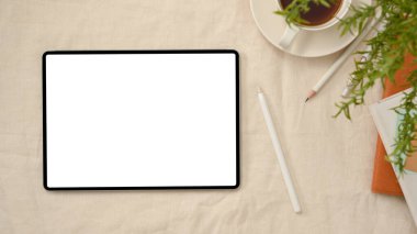 Tablet dokunmatik beyaz ekran modeli, minimal beyaz masa üzerinde, stilus kalem, kahve fincanı ve kırtasiye malzemesi ile. Üst görünüm, kırpma yolu