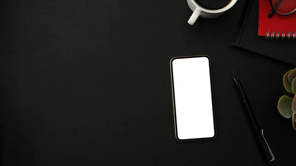 スマートフォンの白い画面のモックアップ オフィス用品や黒の背景にコピースペースと現代の黒いワークスペースの背景 トップビュー — ストック写真