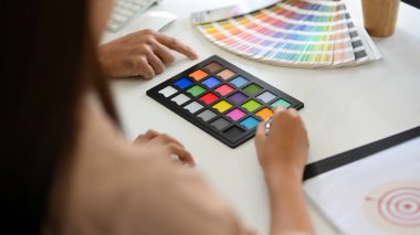 Yakın plan, kadın tasarımcı ve ekibi ofiste birlikte çalışıyorlar, iç projelerini planlıyorlar, binalarının rengini seçiyorlar..