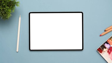 Grafik, stilus kalem, su rengi paleti ve diğer şeyleri mavi arkaplanda göstermek için tablet beyaz ekran modeliyle yaratıcı çalışma alanı üst görünümü.