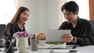 Mutlu iş adamları birlikte çalışıyor. Kadın ve erkek işçi, yaratıcı fikirleri tartışmaktan ve düşünmekten zevk alır..