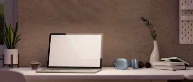 Modern ev çalışma masası portatif laptop boş ekran maketi, kulaklık ve aksesuarlar şık kahverengi duvara karşı. 3d görüntüleme, 3d illüstrasyon