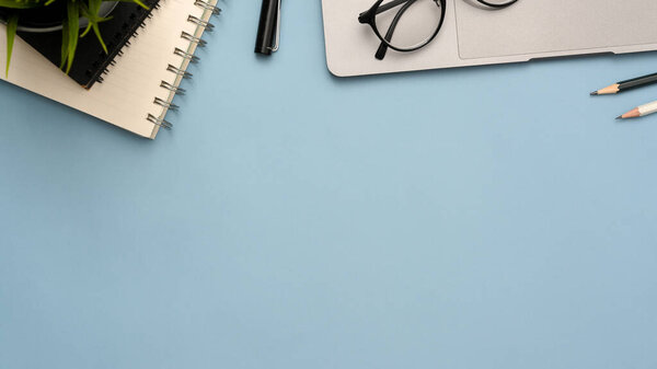 Современный синий стол стол фон с ноутбуком, спиральный блокнот, аксессуары и копировальное пространство.