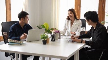 Ofisteki pazarlama stratejisini planlamak için yönetici müdürle toplantı yapan bir pazarlama ekibi..