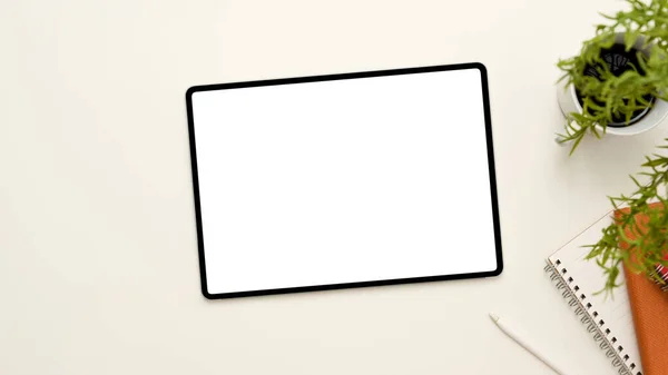 オーバーヘッドショット スマートデジタルタブレットホワイトスクリーンモックアップと白いテーブルの背景に装飾 — ストック写真