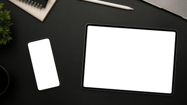 Düz konum, üst görünüm, taşınabilir tablet dokunmatik minimuma sahip minimum siyah ofis masası, akıllı telefon beyaz ekran modeli ve ofis aksesuarları..