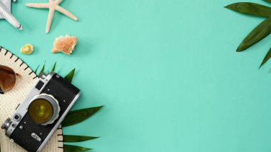 Tatil arkaplanı, yeşil arka planda fotokopi makinesi, plaj şapkası, palmiye yaprakları, güneş gözlüğü, denizyıldızı ve deniz kabukları olan bir yer. Yaz arkaplanı