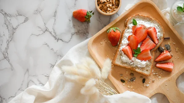美味的健康吐司 白色大理石背景的木制盘子上有草莓 麦片和奶酪 — 图库照片