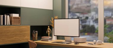 Modern çağdaş ofis içi bilgisayar beyaz ekran maketi ve ahşap masa üzerinde ofis aksesuarları, modern raflar yeşil ve ahşap malzemeler. 3d görüntüleme, 3d illüstrasyon