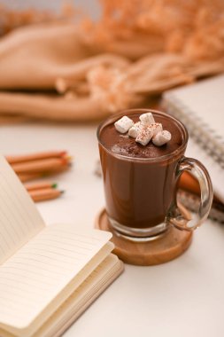 Minimum kış eşyalarıyla en az çalışma alanı ve bir fincan kremalı sıcak çikolata. yakın plan