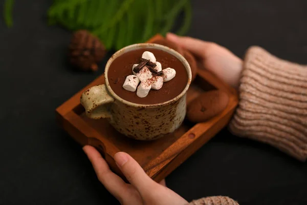 高瞻远瞩 女人的手端着一杯热巧克力和棉花糖 盖在黑桌上 — 图库照片