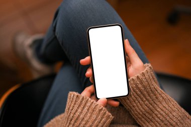 Yakın plan, kadın boş zamanlarını sosyal ağda geçirip arkadaşlarıyla iletişim kurmak için akıllı telefonu kullanıyor. telefon boş ekran modeli.