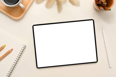 Üst görünüm, düz yatak, dijital tablet beyaz ekran modelli modern ofis masası, beyaz arka planda stilus kalem, kırtasiye ve dekor.