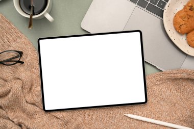 Tepeden çekim, dizüstü bilgisayarlı kadın ofis çalışma alanı, bir fincan kahve, kruvasan ve tablet beyaz ekran modeli..