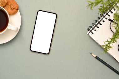 Kırtasiyeli çalışma alanı, bir fincan kahve ve grafiklerinizi göstermek için akıllı telefon beyaz ekran modeli. Üst Manzara Düz Yat