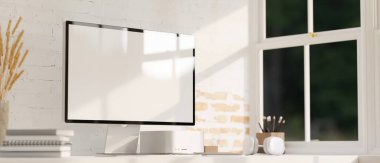 Yakın plan görüntü, beyaz ekran bilgisayar modeli, kulaklık ve kırtasiye malzemesi beyaz masa üstünde pencerenin yanındaki beyaz tuğladan duvara karşı. 3d görüntüleme, 3d illüstrasyon