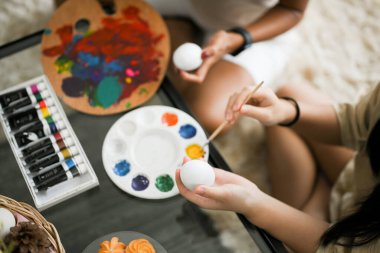 Kırpılmış atış, Mutlu anne ve kız oturma odasında renkli bir Paskalya yumurtası boyamaktan zevk alıyorlar. Paskalya yumurtası boyama kavramı