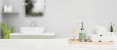 Banyo aksesuarları, aroma yayıcı, sabun şişesi, el havluları ve arka plandaki bulanık banyonun üstündeki beyaz banyo masasında fotokopi alanı. 3d görüntüleme, 3d illüstrasyon