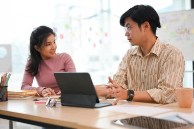 Zeki Asyalı erkek asistan, ekibiyle yaptığı gayri resmi toplantıda yaratıcı fikrini bayan meslektaşlarına sunar..