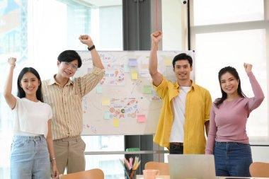 Başarıyı kutlayan Asyalı genç iş adamları ofiste birlikte hedefe ulaşırlar. Başarılı bir başlangıç grubu