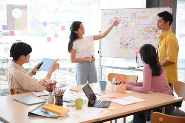 Çekici Asyalı iş kadını eğitimi ve toplantıda takımlarına koçluk. Beyin fırtınası konsepti