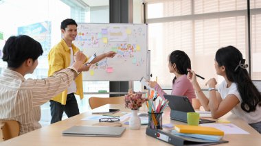 Bir grup akıllı işletme girişimi, patronlarının antrenmanlarını ve pazarlama planlarını toplantı odasında dinliyor. Takım çalışması konsepti.