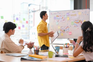 Asyalı genç girişimci takım toplantısı ofiste, iş stratejilerini tartışıyor ve planlıyorlar..