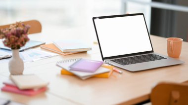 Yakın plan, laptopta bilgisayar beyaz ekran modeli ve aksesuarları olan kafede çalışma alanı.