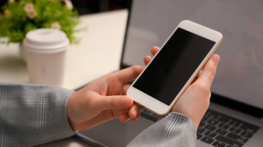 Yakın plan, resmi takım elbiseli iş kadını ofis masasının üzerinde akıllı telefon kullanıyor. telefon siyah ekran.
