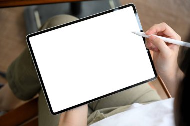 Yakın çekim, kadın girişimci girişimi sıradan bir kıyafet içinde, dijital tablete kendi grafik afişini tasarlıyor. Tablet beyaz ekran modeli.