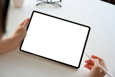 Yakın plan görüntü, çalışma masasında dijital tablet dokunmatik ped kullanan kadın grafik tasarımcısı. Tablet beyaz ekran modeli.