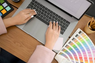 Üst görünüm, Modern grafik tasarımcı ofis çalışma alanı konsepti, dizüstü bilgisayar üzerinde çalışan kadın grafik tasarımcısı.