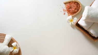 Spa arka planı, spa havluları, pembe organik tuz, masaj topları, frangipani ve beyaz arka planda kopyalama alanı.