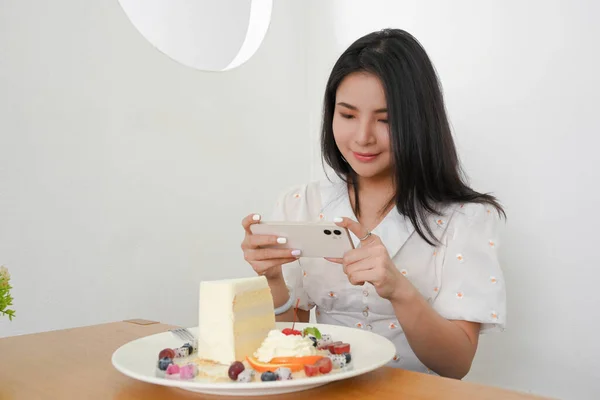 Piękna Azjatycka Milenijna Kobieta Robi Pyszne Zdjęcia Deserów Smartfonem Kawiarni — Zdjęcie stockowe
