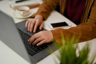 Yakın plan, kadın çalışan, serbest çalışan, dizüstü bilgisayar kullanan, klavyede yazan üniversite öğrencisi..