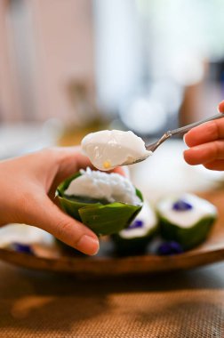 Kaşıkla Tayland hindistan cevizli puding yiyen bir kadın. Yakın plan görüntü, Geleneksel Tayland tatlıları konsepti 