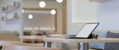 Yakın plan görüntü, sehpanın üzerinde taşınabilir tablet modeliyle modern ve minimal iç tasarımla dekore edilmiş kafe oturma alanı. 3d görüntüleme, 3d illüstrasyon