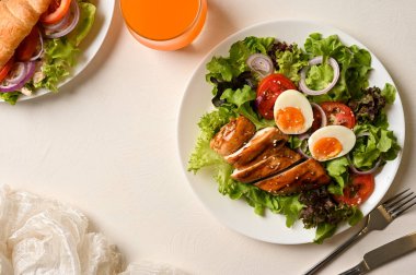 Sağlıklı diyet kahvaltı, tavuk göğsü salatası, taze tavuk, sebzeli kruvasan ve bir bardak portakal suyu..