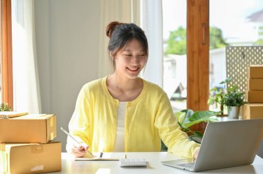 Girişim KOBİ küçük işletme girişimcisi Asyalı genç bayan mağazasındaki dizüstü bilgisayarında çalışıyor. e-ticaret işi.